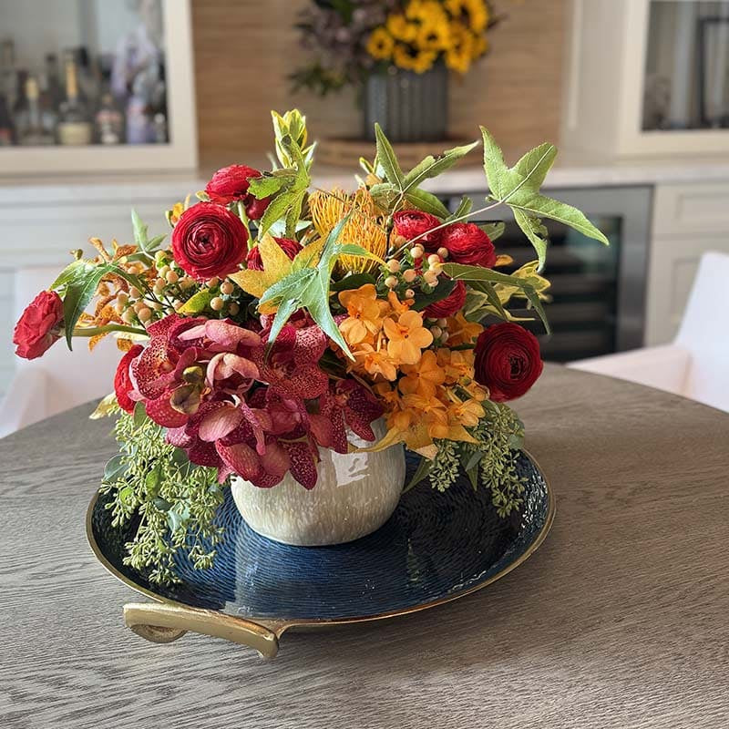 Colorful flower arrangement on a decorative tray in a home setting