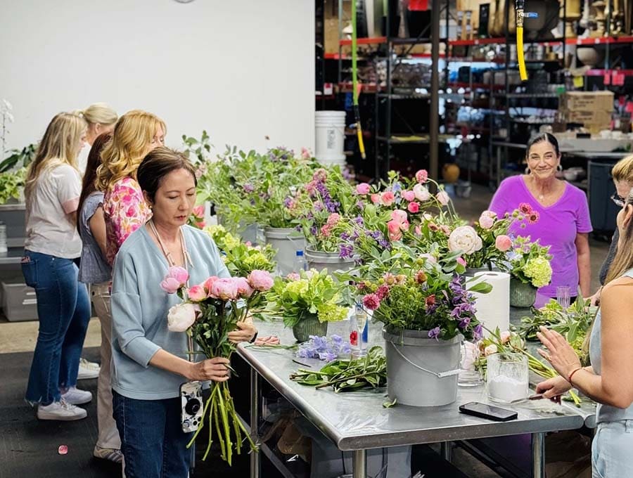 Group of people working with flowers in a workshop setting