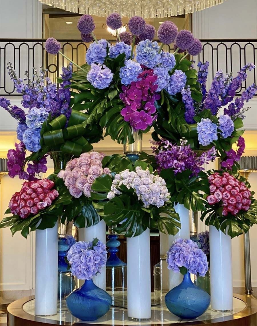 Colorful floral arrangement with various flowers in vases on a table.