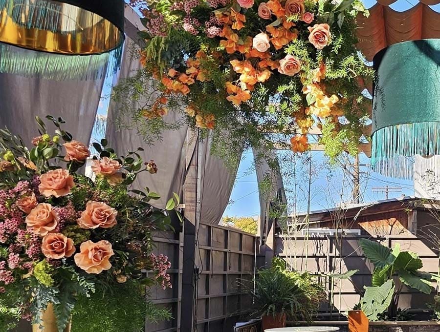 Decorative floral arrangements with hanging lights in an outdoor setting