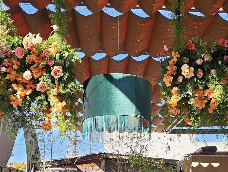 Decorative floral arrangements hanging from a ceiling with a blue light fixture.