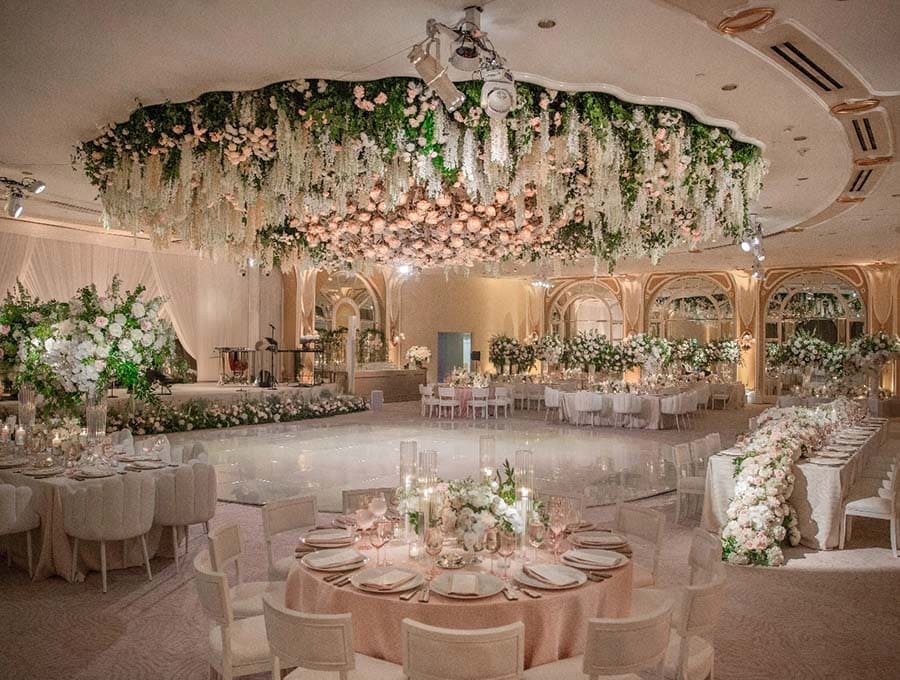 Decorated banquet hall with floral arrangements and chandeliers