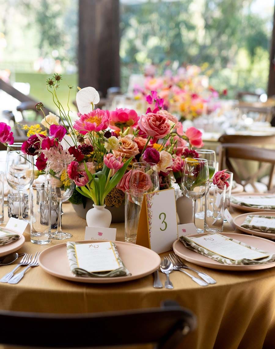 Decorated table with floral centerpieces and place settings outdoors