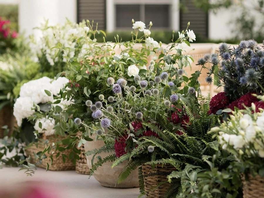 Decorative floral arrangements in woven baskets on a table outdoors.